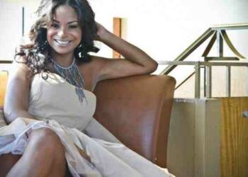 Joyful Drake in white dress and sitting of brown sofa