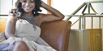 Joyful Drake in white dress and sitting of brown sofa