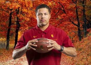 Donte Williams holding a rugby ball in woods
