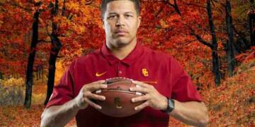Donte Williams holding a rugby ball in woods