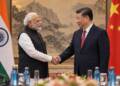 Indian Prime Minister Narendra Modi and Chinese President Xi Jinping shake hands during a formal diplomatic meeting, with the Indian and Chinese flags displayed behind them.