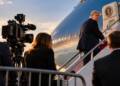 Donald Trump boards a presidential aircraft as journalists and television cameras watch from behind a barrier on the tarmac.CNN