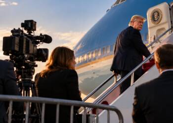 Donald Trump boards a presidential aircraft as journalists and television cameras watch from behind a barrier on the tarmac.CNN