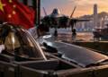 F-35 stealth fighter components being examined beside a fighter jet and shipping containers in Hong Kong, with Chinese imagery in the background, depicting concerns over sensitive aircraft technology reaching China.