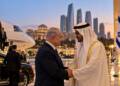 Israeli Prime Minister Benjamin Netanyahu meets UAE President Sheikh Mohamed bin Zayed in Abu Dhabi, with a private jet, security officials and Israeli and UAE flags visible in the background.
